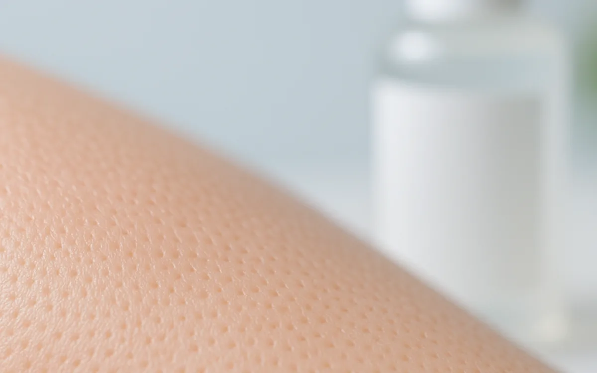 Close-up of a nose area with a salicylic acid cleanser bottle nearby